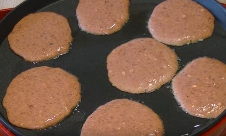 Con un mestolo o un cucchiaio, metti le frittelle su una padella calda.