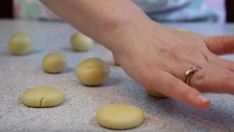 Per i cappelli, arrotoliamo i pezzi di pasta in palline e li stringiamo a mano.