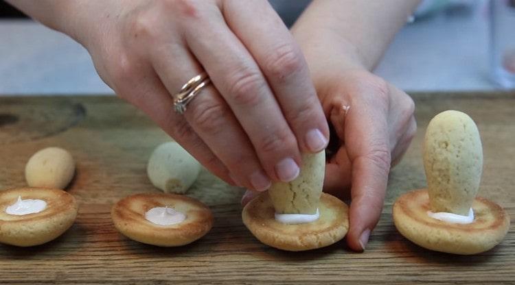 Spremi una piccola glassa negli incavi dei tappi dei funghi e inserisci le gambe lì.