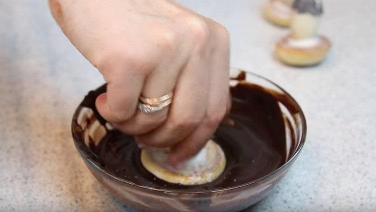 Tappi per funghi immersi nel cioccolato fuso.