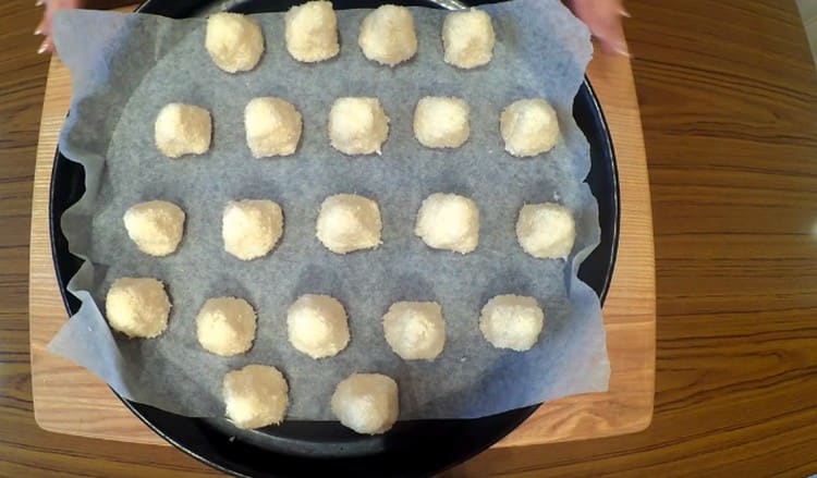 Rotoliamo le palline dalla massa di cocco e le mettiamo su pergamena.