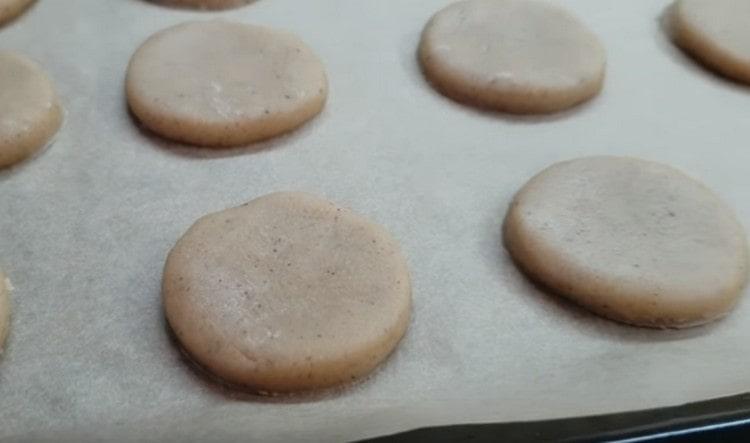 Inilatag namin ang mga blangko sa isang baking sheet na natatakpan ng pergamino.