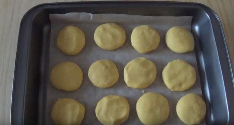 Copri la teglia con carta da forno e mettici sopra dei biscotti.