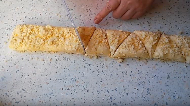 Cospargere il pezzo con le briciole rimanenti e tagliarlo a triangoli.