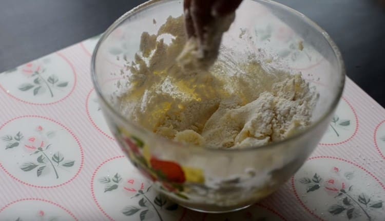 Setaccia la farina nella massa oleosa, inizia a impastare la pasta.