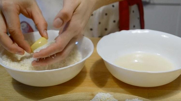 Immergere ogni biscotto nella glassa, quindi arrotolare il cocco.