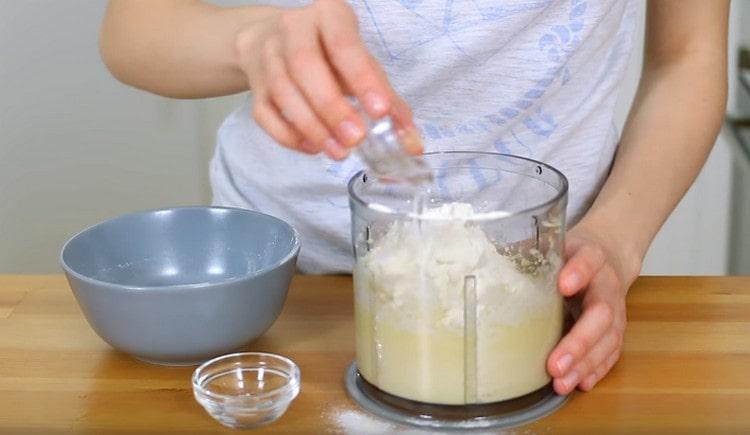 Quindi, aggiungi sale, farina e vodka nella massa di formaggio al burro.