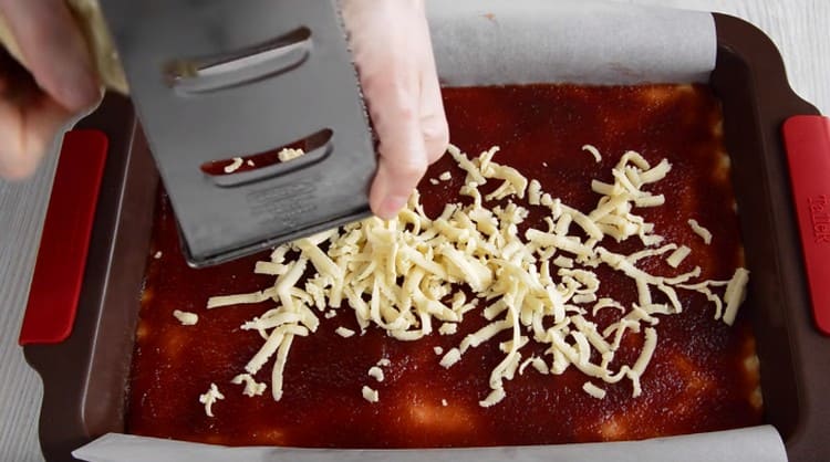 Su una grattugia grossa sopra la marmellata, strofina un pezzettino di pasta congelata.