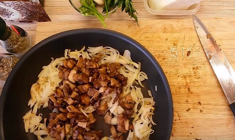 Tagliare i funghi a pezzi e aggiungerli alla cipolla nella padella.