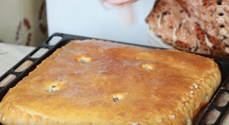 Una torta calda con carne e patate può essere unta con un pezzo di burro.