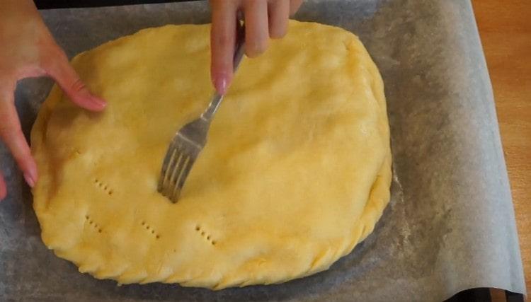 Pungiamo la torta con una forchetta in modo che non si gonfia durante la cottura.