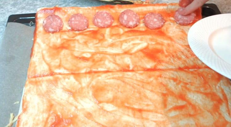 Spalmiamo sulle fette di pita di salsiccia.