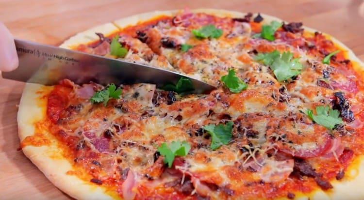 La meravigliosa pizza a base di carne può essere guarnita con erbe fresche quando viene servita.