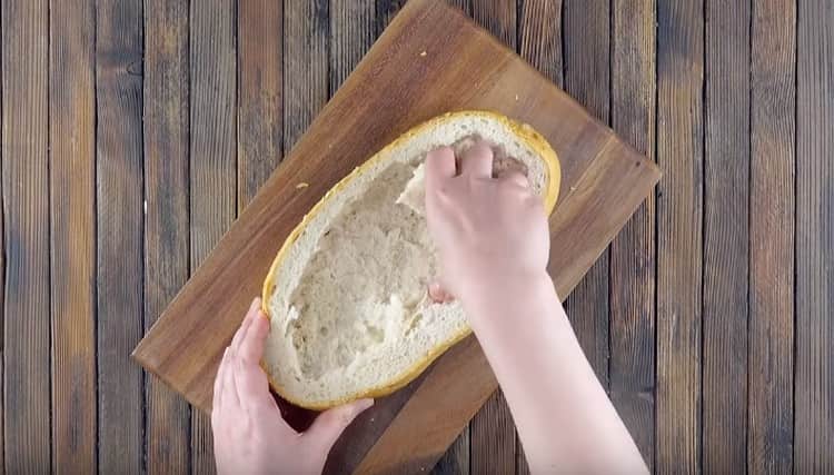 Tagliare la pagnotta a metà e rimuovere la briciola dal fondo.