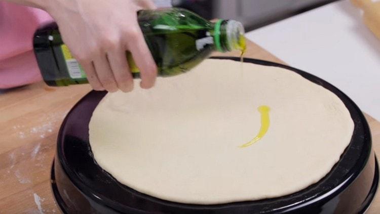 stendiamo l'impasto su una teglia unta con olio vegetale, in cima ingrassiamo anche con olio.