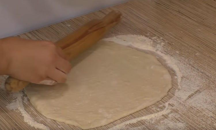 Dividi l'impasto a metà e arrotoli ogni parte in un cerchio.