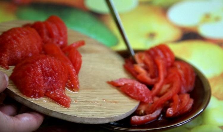 Tagliare i pomodori a semicerchio.