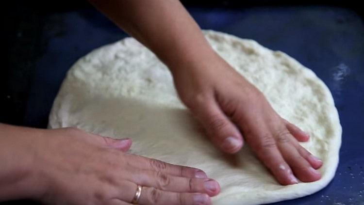 Dividendo l'impasto in 3 parti, ognuna di esse è allineata su una teglia da forno unta di olio vegetale in un cerchio.