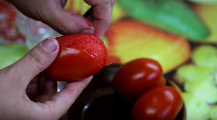 Prendiamo i pomodori dall'acqua bollente e li sbucciamo.