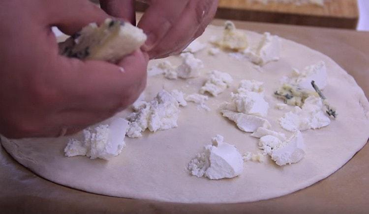 Tra i pezzi di ricotta, stendi il gorgonzola.