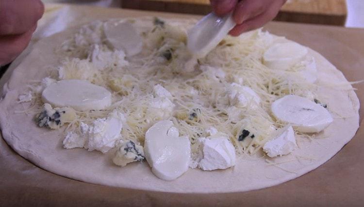 Aggiungere le fette di mozzarella e cospargere il tutto con il parmigiano.