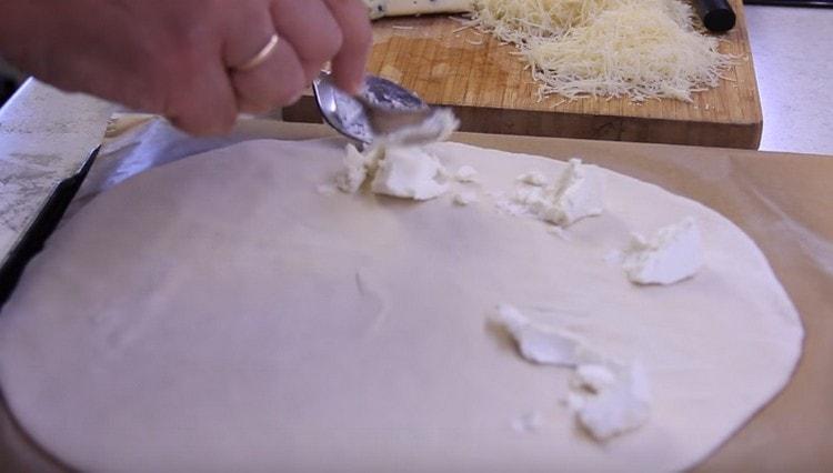 Per prima cosa, metti la ricotta sull'impasto.