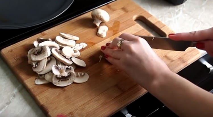 Puliamo e tagliamo i funghi a fette.