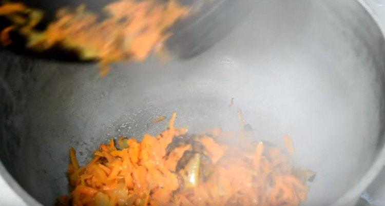 Spostiamo le carote con le cipolle in un calderone, che poi invieremo al forno.