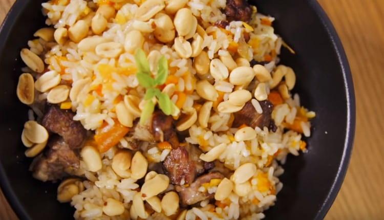 Pilaf cosparso di maiale e albicocche secche e servire con arachidi salate.