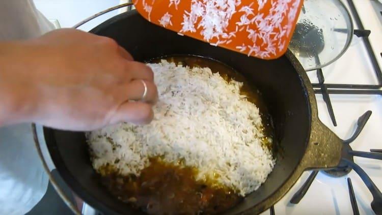 Distribuire uniformemente il riso sulla carne con le verdure.