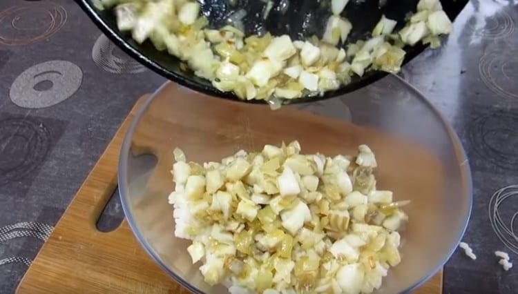 Prepariamo il ripieno combinando riso bollito con cipolle e pesce.