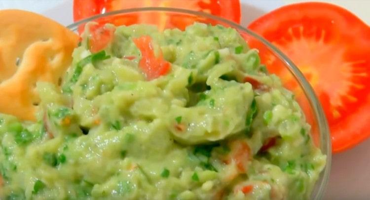 La salsa di guacamole, preparata secondo la ricetta classica con avocado, può essere servita con vari snack.