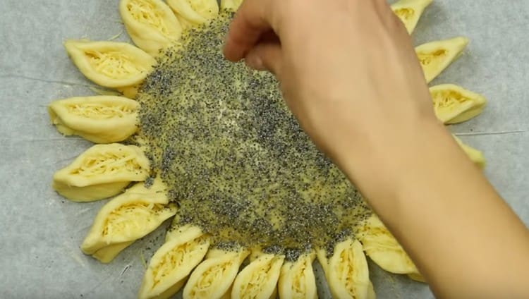 Ungere il centro della torta con il tuorlo e cospargere con i semi di papavero.