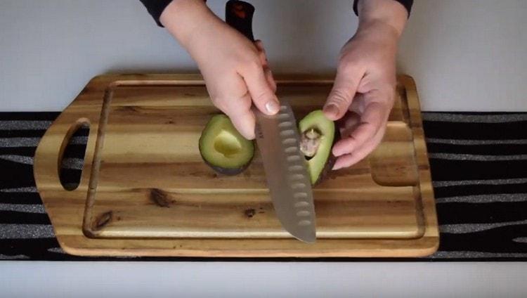 tagliare l'avocado a metà ed estrarre una pietra.