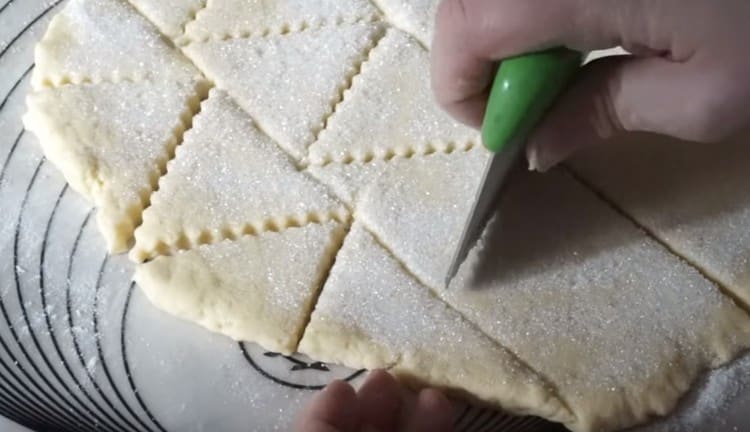 Con un coltello riccio, tagliare la pasta a triangoli.