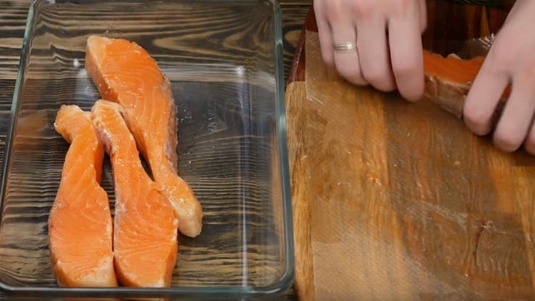 Distribuiamo i pezzi di salmone con una teglia con i lati.