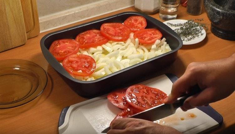 Sopra lo strato di cipolla, stendi i pomodori a fette.