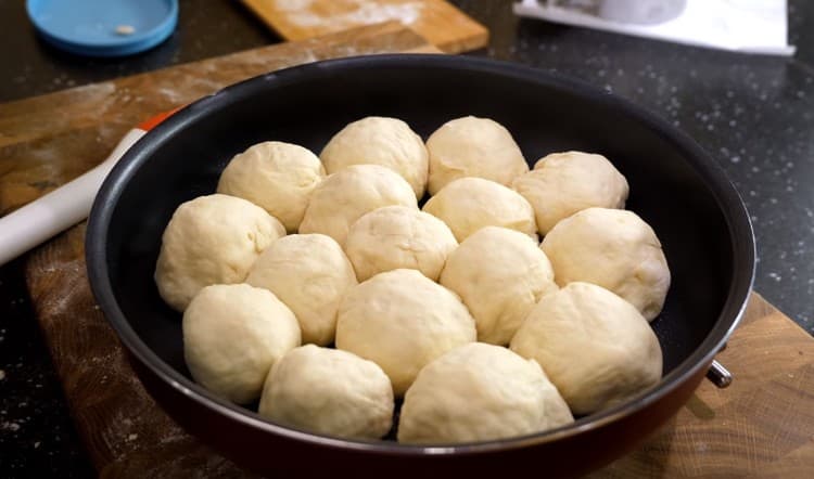 Formiamo palline con formaggio dall'impasto e le mettiamo in una teglia.