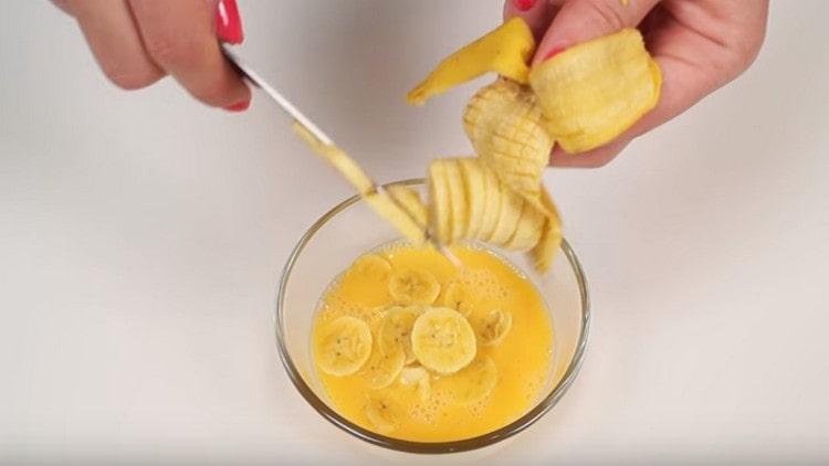 Per preparare il ripieno, sbatti l'uovo e aggiungi la banana.