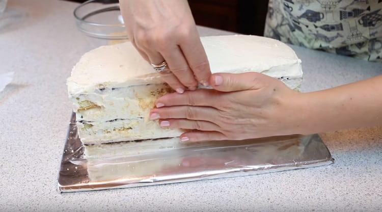 Dopo aver ingrassato i lati della torta con la panna rimasta, cospargeteli di briciole di biscotti.