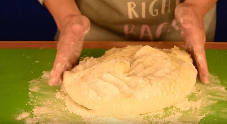 Trasferire l'impasto su una superficie di lavoro e impastare fino a quando non smette di aderire alle mani.