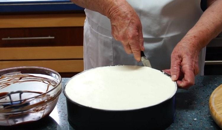 Usando un coltello sottile, disegna lungo il bordo dello stampo con una torta per separarlo dalle pareti.