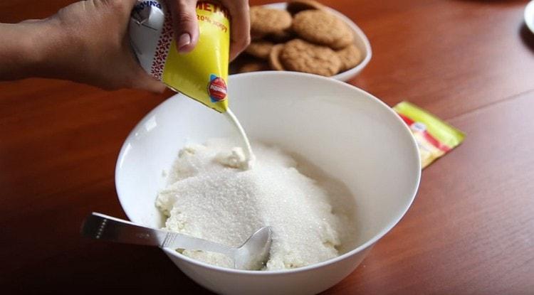 In una ciotola profonda uniamo ricotta, zucchero, zucchero vanigliato e panna acida.