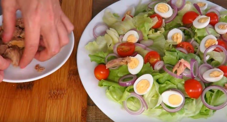 Rompiamo pezzi di tonno in scatola e li distribuiamo su ingredienti già preparati.