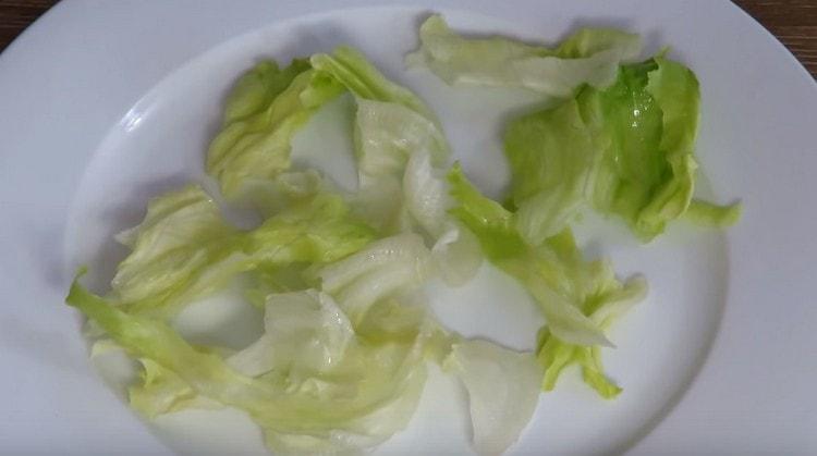 Metti l'insalata di iceberg su un grande piatto da portata.