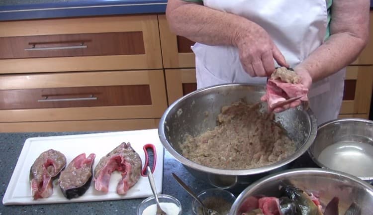 Riempiamo i pezzi di pesce e la testa con carne macinata.