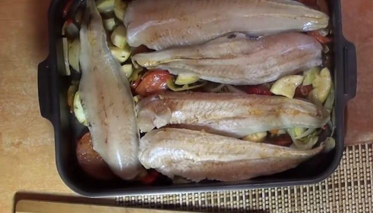 Dopo 10 minuti, metti il ​​pesce sulle verdure e mettilo in forno.