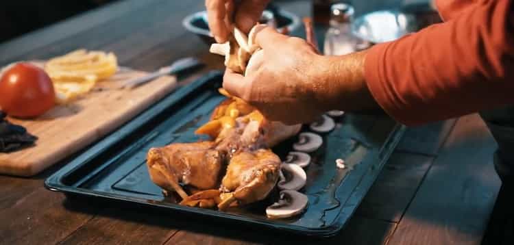 Cucinare l'intero coniglio nel forno. mettere i funghi su una teglia