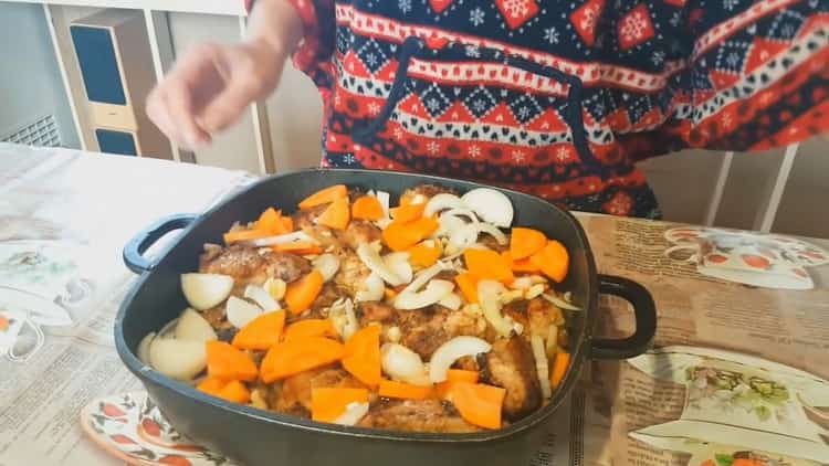 Per cucinare un coniglio in umido con verdure, metti le verdure sulla carne