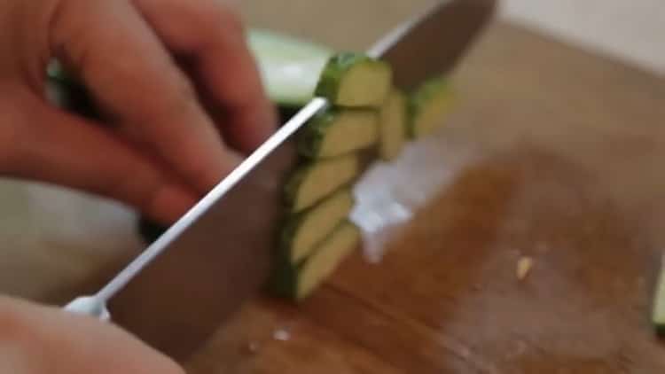 Per cuocere il salmone al forno in un foglio, tagliare un cetriolo